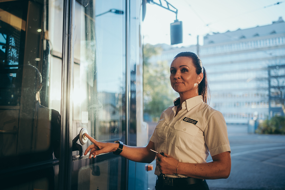 Spårvagnsförare trycker på knapp för att öppna dörrarna på en spårvagn