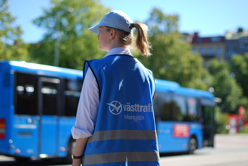 Informatör i arbete intill stillastående buss