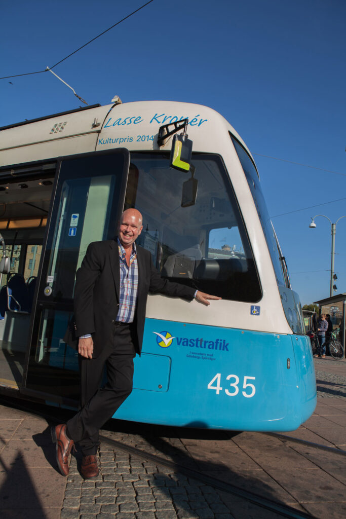 Lasse Kronér poserar framför spårvagn
