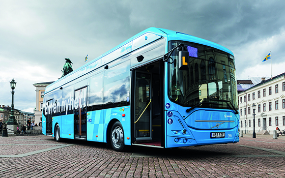 Bild på blåbuss som står parkerad på ett torg