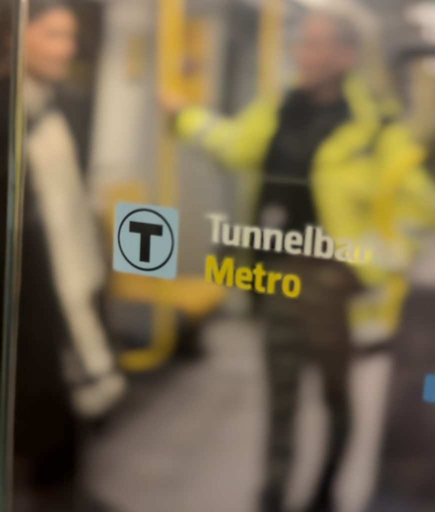 Klistermärke på glasvägg med text: Tunnelbana Metro